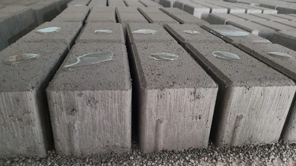 aditivos para concreto: blocos de concreto com pequenas poças de água em cima, mostrando que são impermeáveis